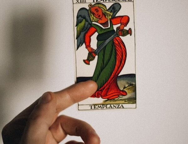 a person holding up a card with a devil on it