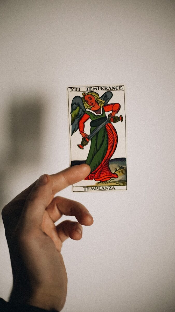 a person holding up a card with a devil on it